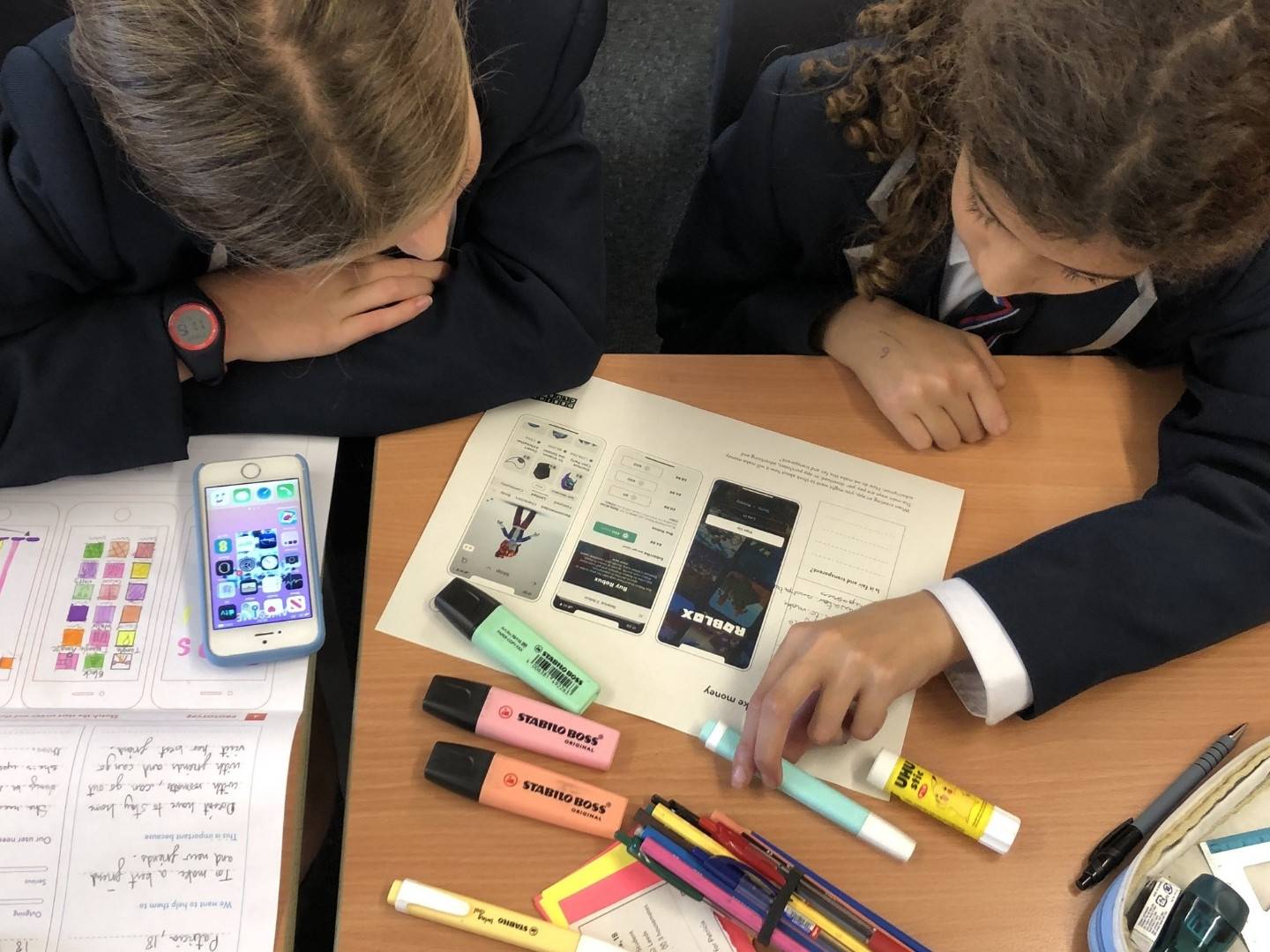 Two girls complete the worksheet on how apps make money