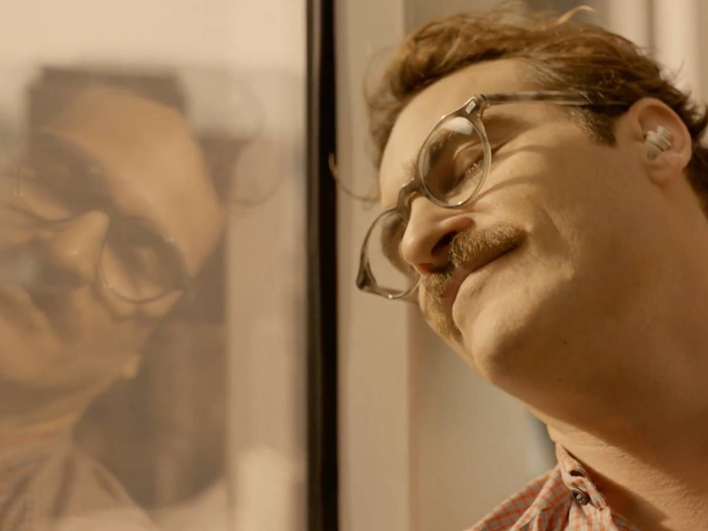 A screenshot from the film Her showing Joaquin Pheonix connecting with his AI companion