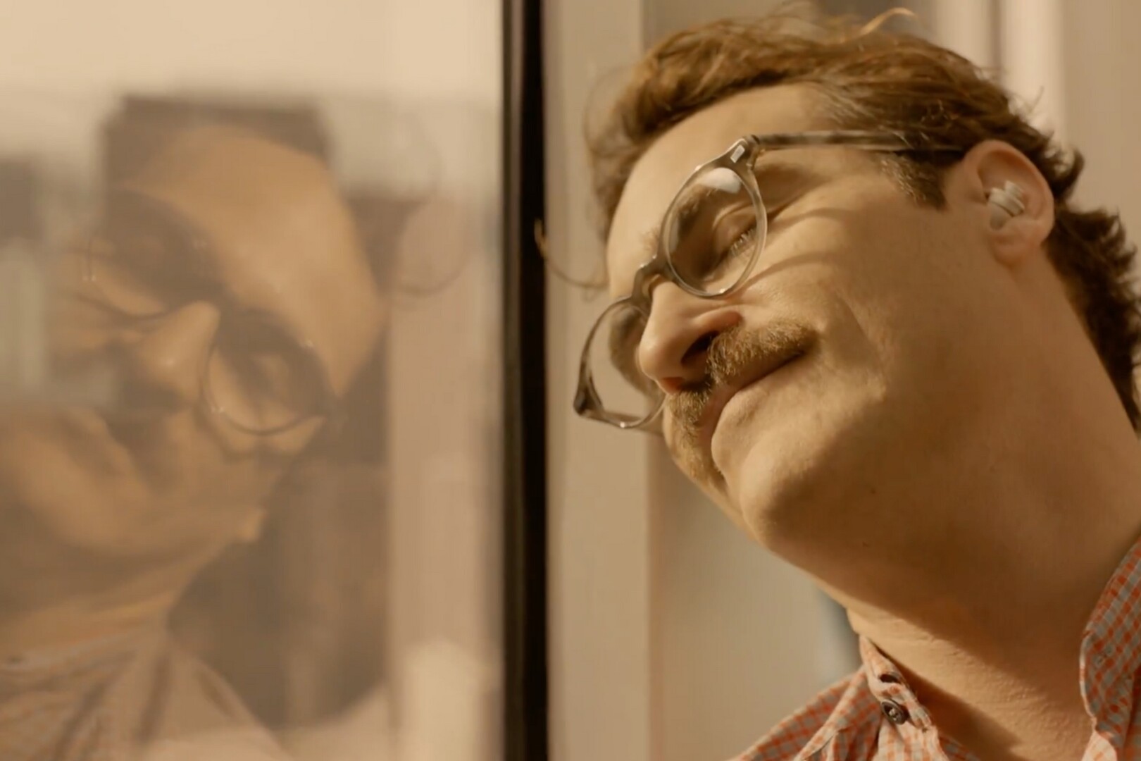 A screenshot from the film Her showing Joaquin Pheonix connecting with his AI companion